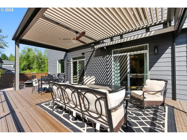 a view of a patio with table and chairs with wooden floor and fence