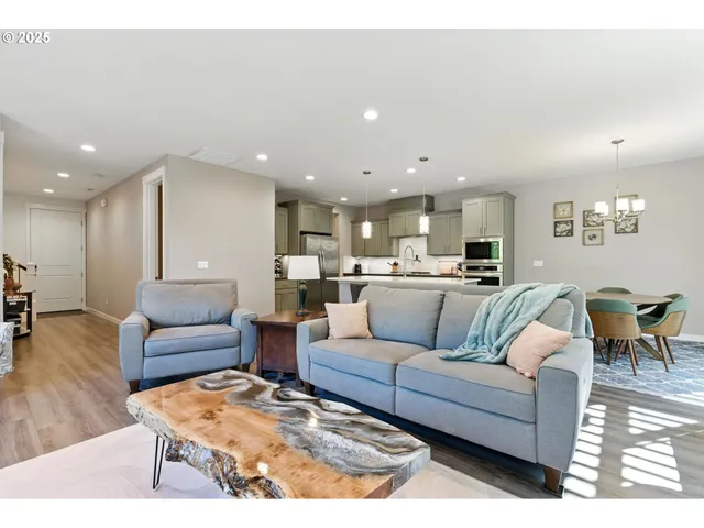 a living room with furniture and a dining table with kitchen view