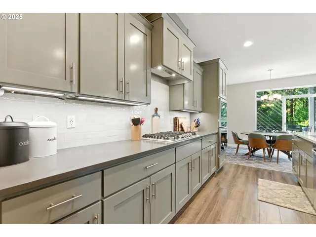 a kitchen with granite countertop a sink cabinets and wooden floor