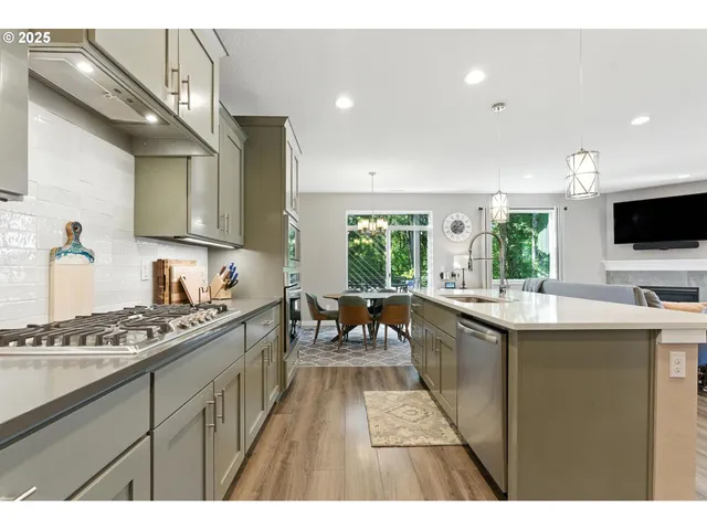 a kitchen with stainless steel appliances kitchen island granite countertop a sink stove and cabinets