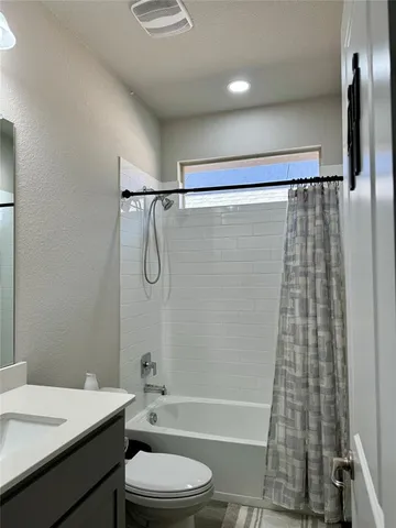 a bathroom with a shower a toilet and sink