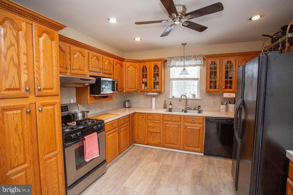 406 Walnut Avenue Laurel Springs, NJ 08021 - Photo 10 of 20 a kitchen with stainless steel appliances granite countertop a refrigerator a sink dishwasher a stove and white cabinets with wooden floor