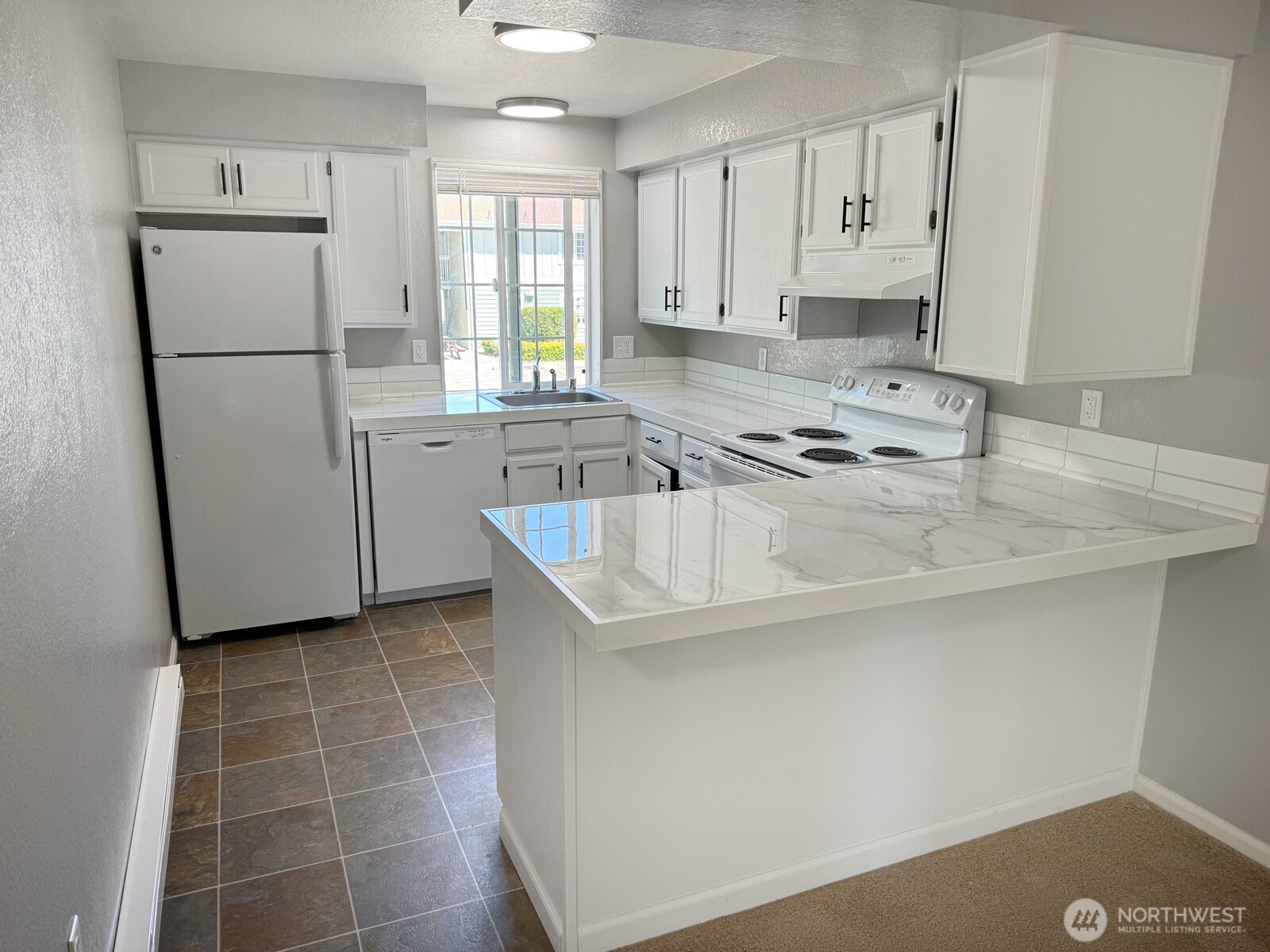 820 32nd Street Bellingham, WA 98225 - Photo 26 of 39 a kitchen with a refrigerator a stove a sink a counter top space and cabinets