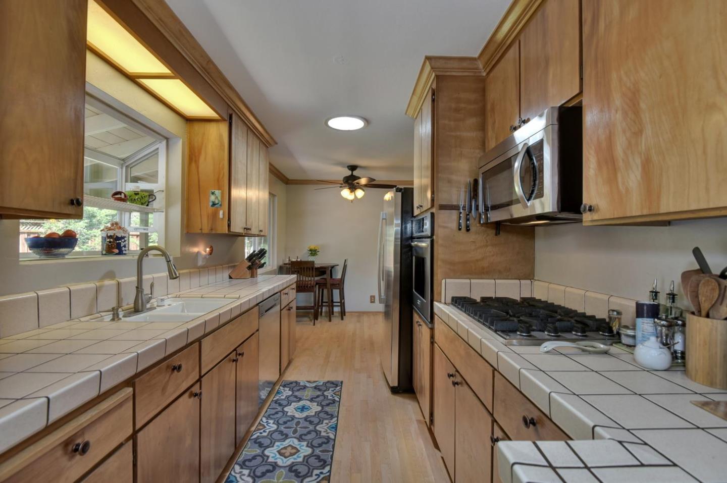 1175 Llagas Road Morgan Hill, CA 95037 - Photo 13 of 37 a kitchen with granite countertop a sink a stove and cabinets