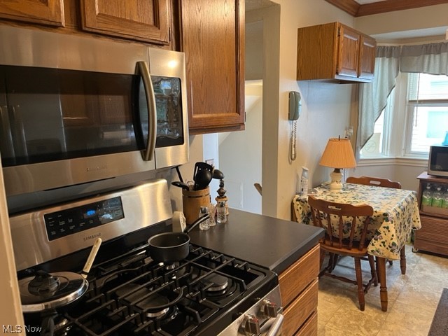 1227 Winston Road Cleveland, OH 44121 - Photo 3 of 15 Kitchen with stove, light tile floors, and ornamental molding