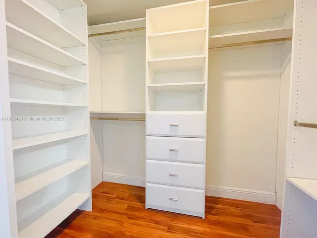 a view of walk in closet with empty racks