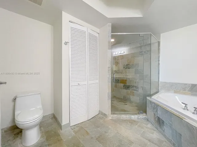a bathroom with a granite countertop toilet a sink and shower