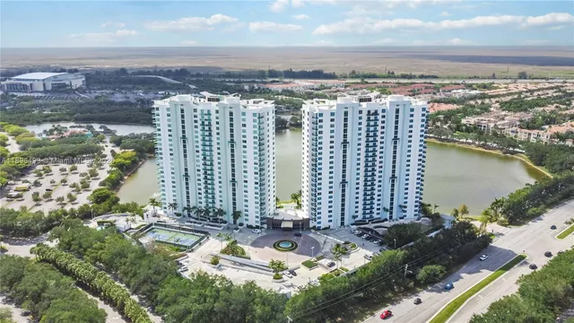 an aerial view of ocean and residential houses with outdoor space