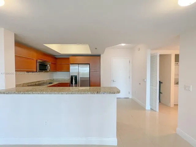 a large white kitchen with a refrigerator a sink and a stove
