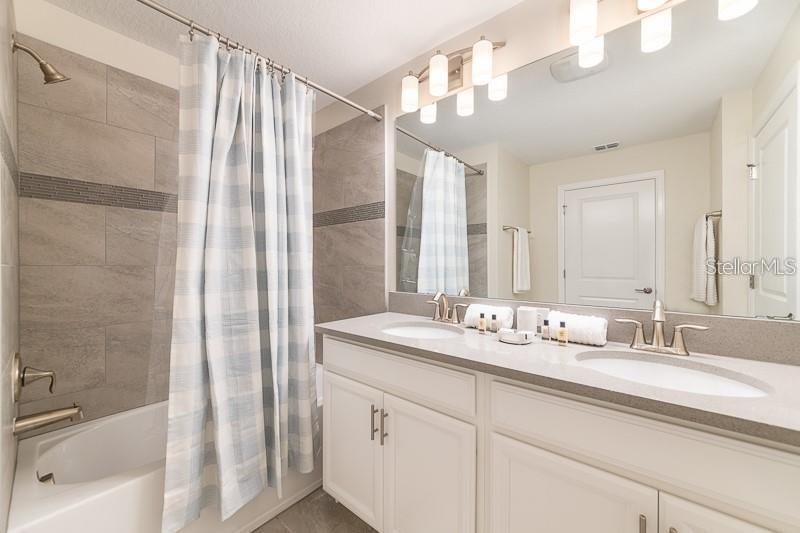 5025 Windermere Avenue Kissimmee, FL 34746 - Photo 14 of 33 a bathroom with a double vanity sink mirror and shower