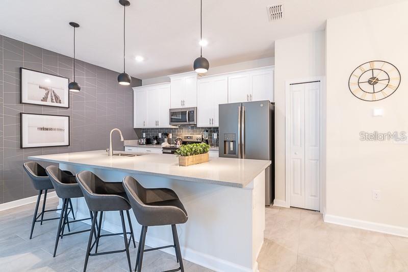 5025 Windermere Avenue Kissimmee, FL 34746 - Photo 3 of 33 a kitchen with stainless steel appliances kitchen island a refrigerator and a stove