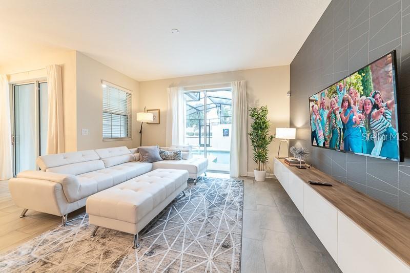 5025 Windermere Avenue Kissimmee, FL 34746 - Photo 5 of 33 a living room with furniture large window and flat screen tv