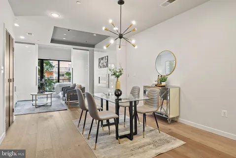 a dining room with chandelier fan and wooden floor