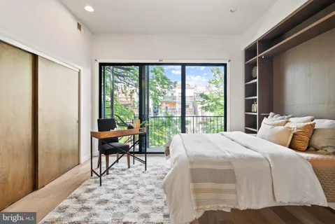 a bedroom with a bed and a large window