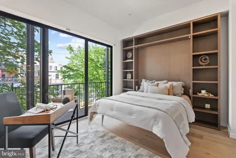 a bedroom with a bed and a large window