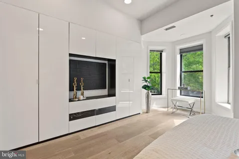 a bedroom with a bed and a large window