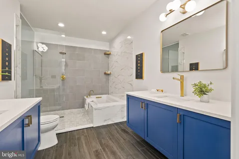 a spacious bathroom with a bathtub shower sink mirror and toilet