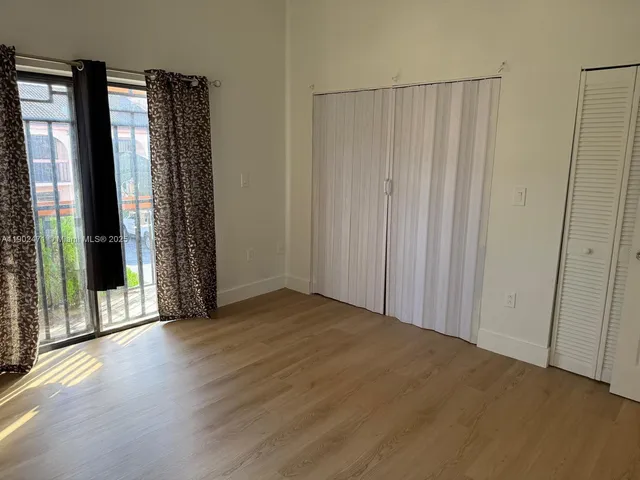 a view of a room with wooden floor and a window