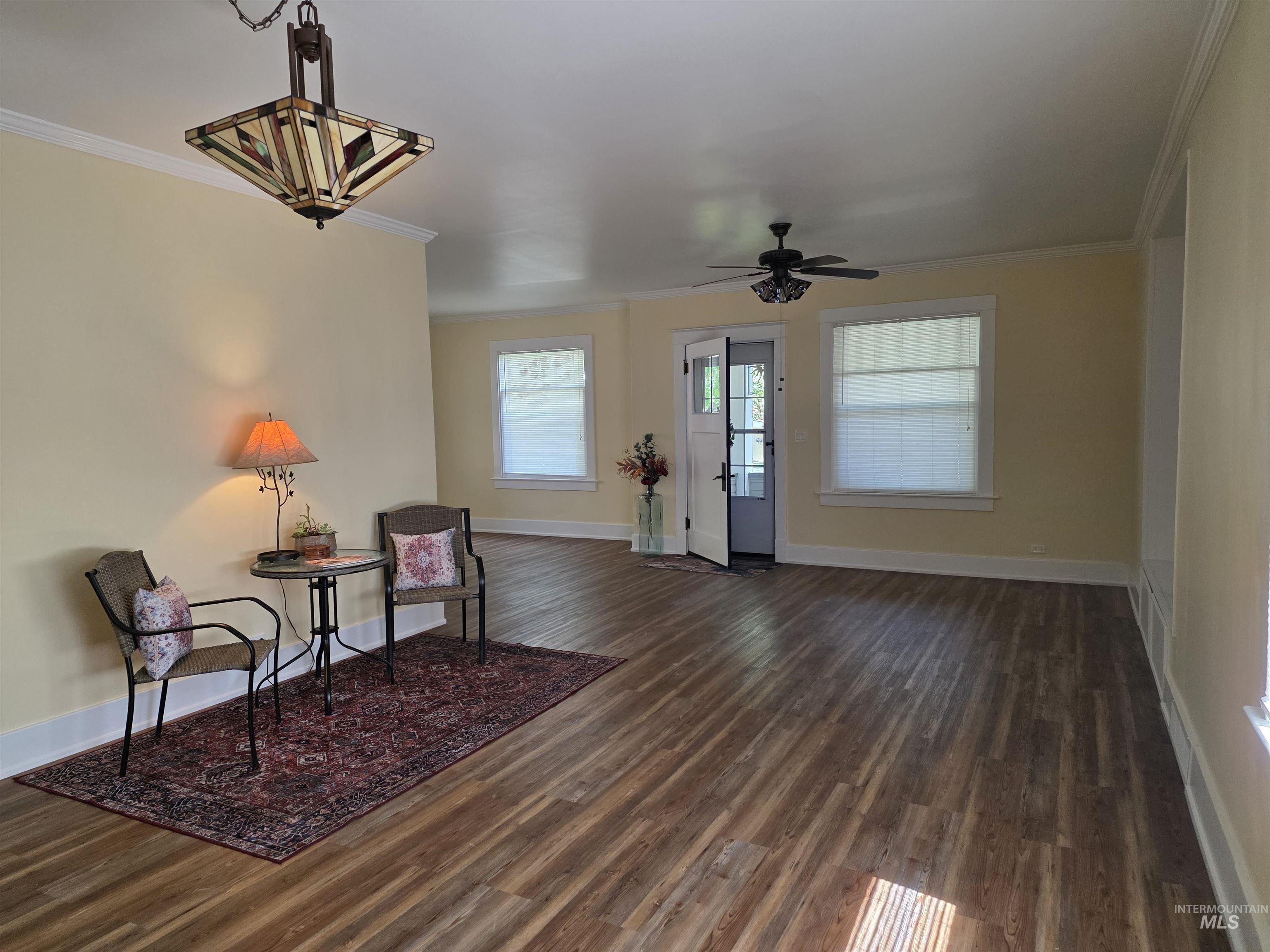 421 East Main Street Jerome, ID 83338 - Photo 4 of 13 Spacious room featuring wood-finish flooring, light-toned walls, and a decorative ceiling light fixture