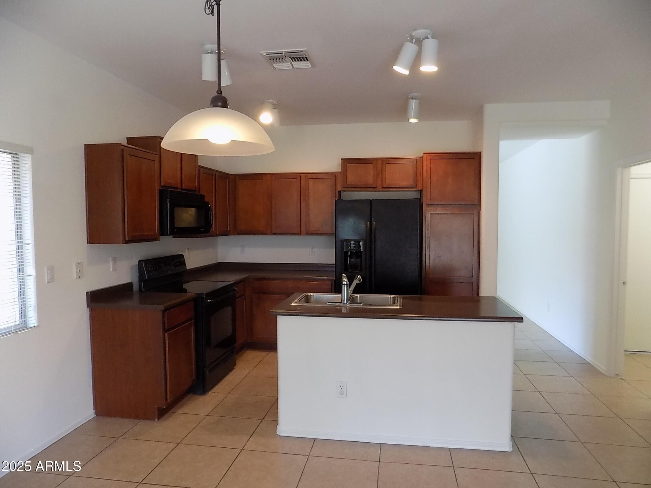 5423 West Shumway Farm Road Laveen, AZ 85339 - Photo 3 of 21 a kitchen with kitchen island granite countertop stainless steel appliances a sink a counter top space cabinets and a window