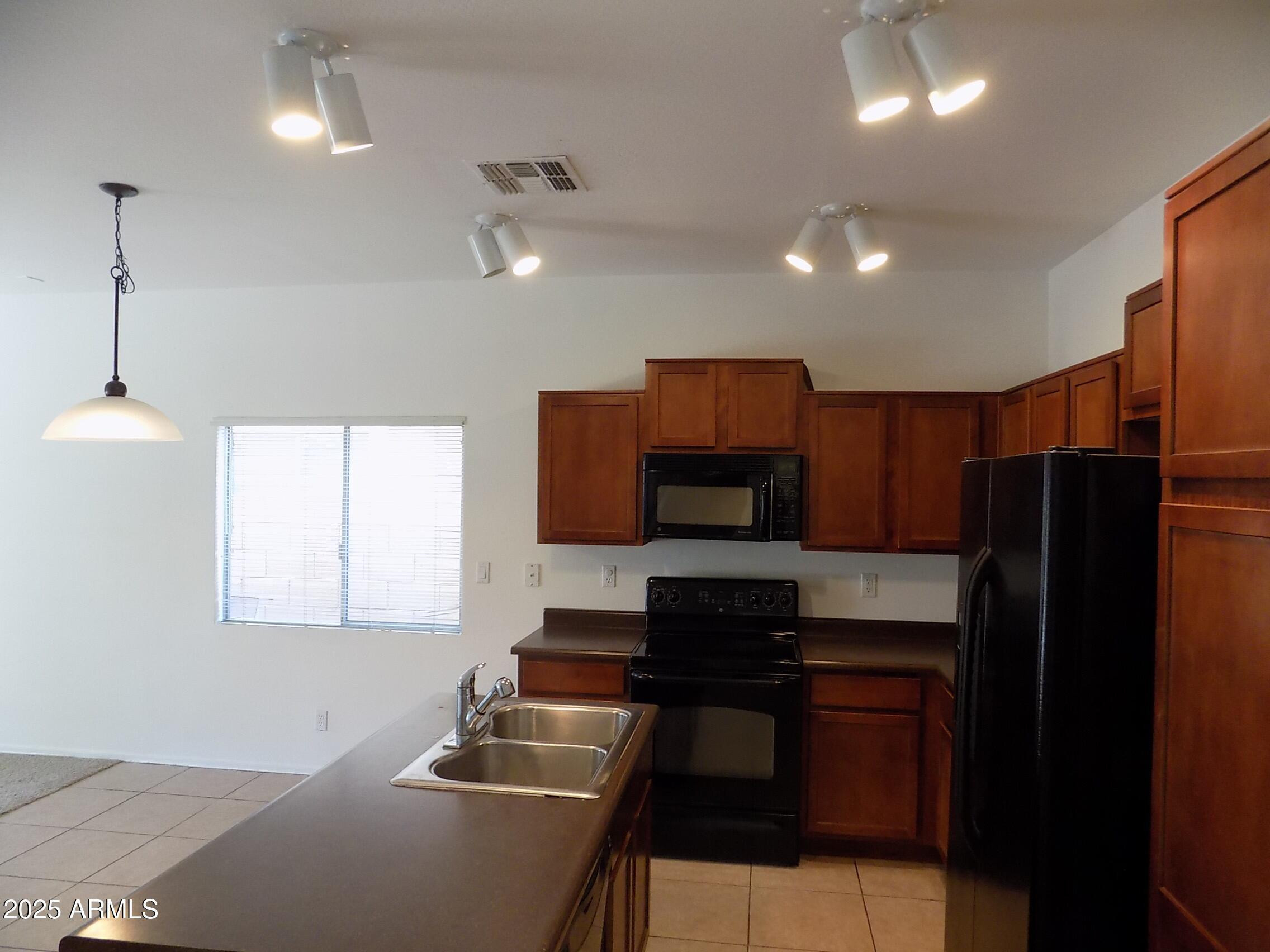5423 West Shumway Farm Road Laveen, AZ 85339 - Photo 5 of 21 a kitchen with a refrigerator and a stove top oven