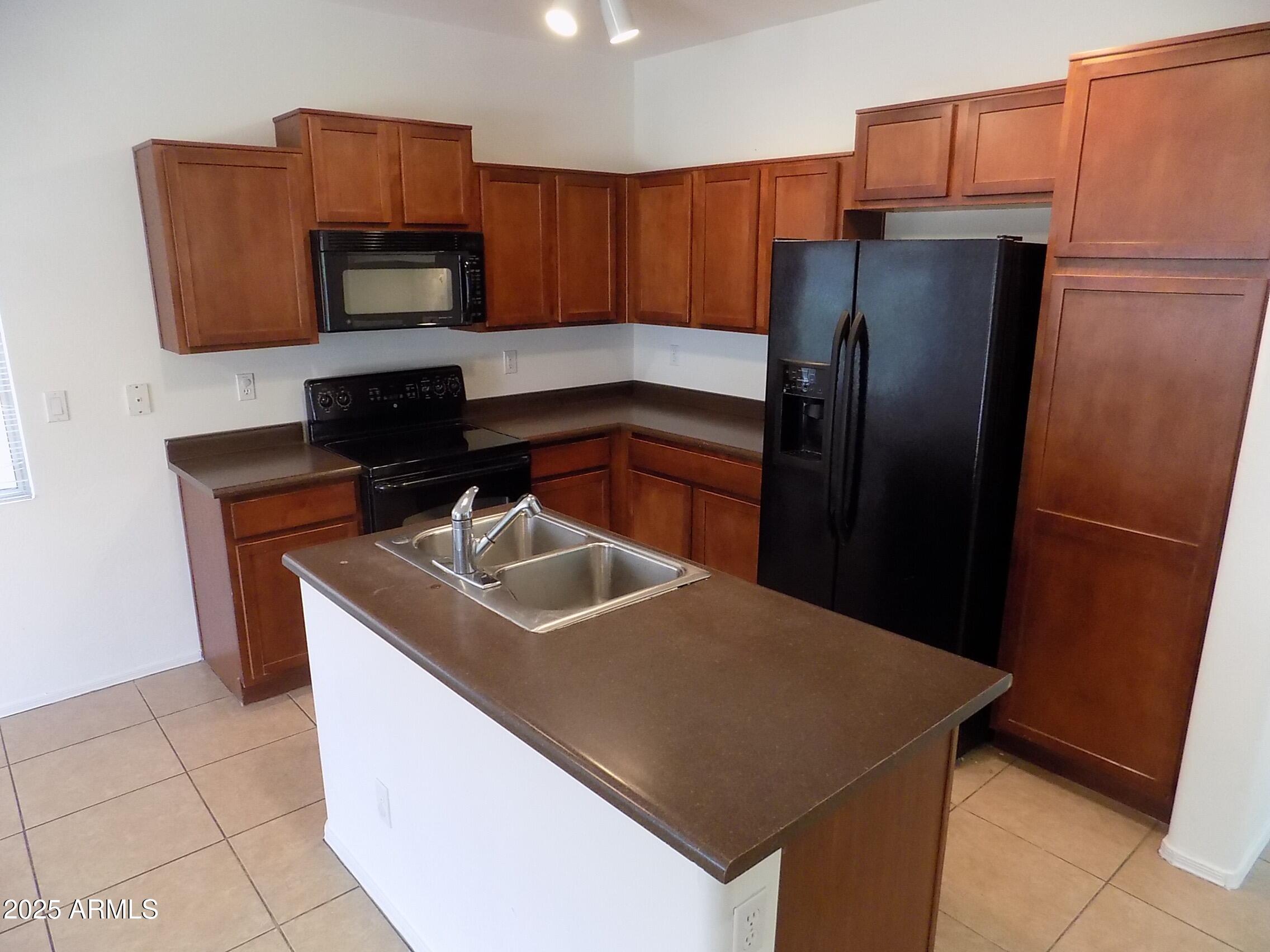 5423 West Shumway Farm Road Laveen, AZ 85339 - Photo 6 of 21 a kitchen with stainless steel appliances a refrigerator a sink a stove a microwave a sink and cabinets