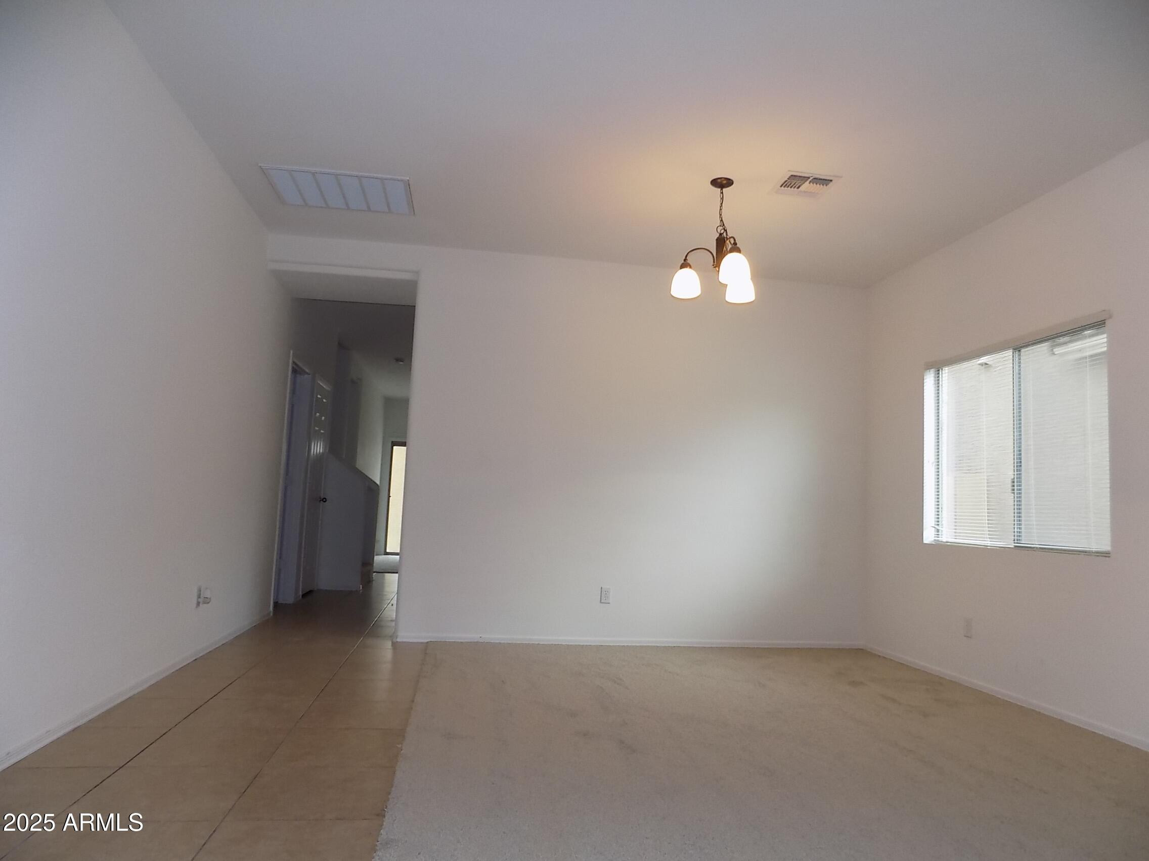 5423 West Shumway Farm Road Laveen, AZ 85339 - Photo 7 of 21 an empty room with a window and a chandelier fan