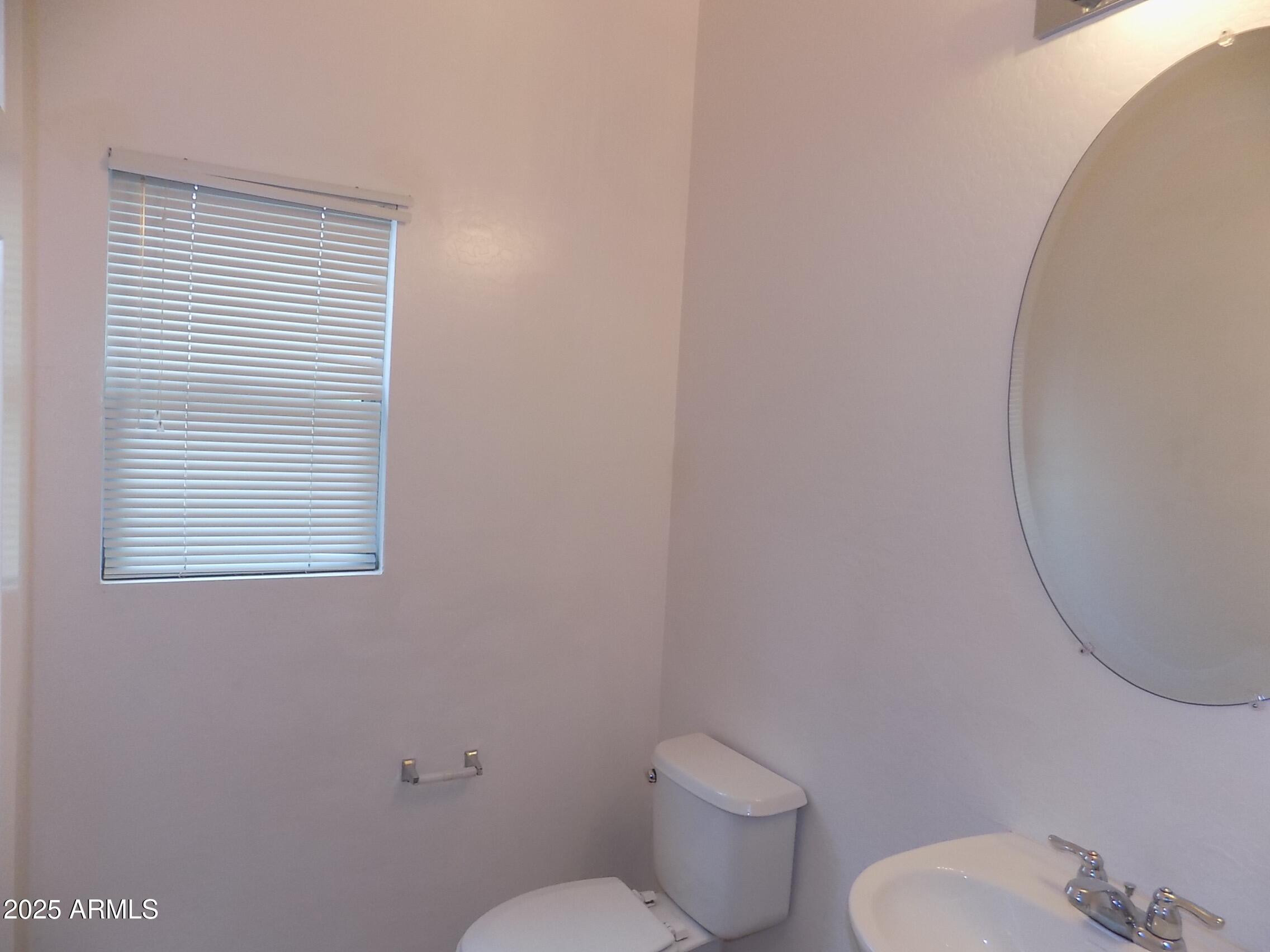 5423 West Shumway Farm Road Laveen, AZ 85339 - Photo 9 of 21 a white toilet sitting next to a white sink and vanity