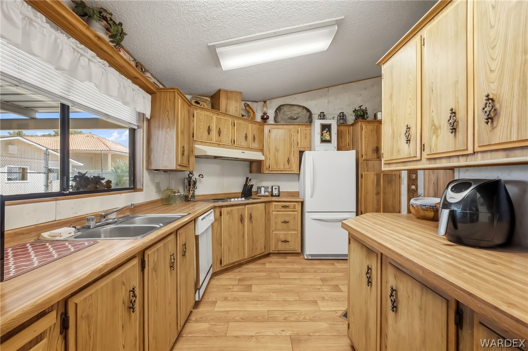 10031 Dike Road Mohave Valley, AZ 86440 - Photo 58 of 78 a kitchen with granite countertop a sink and a refrigerator