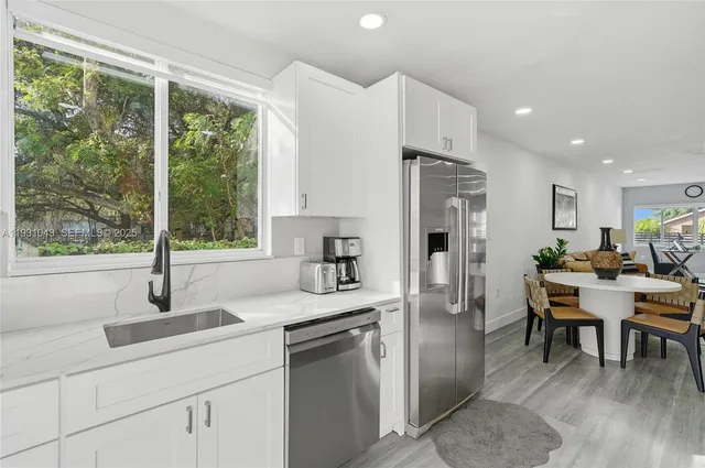 a kitchen with refrigerator cabinets and wooden floor