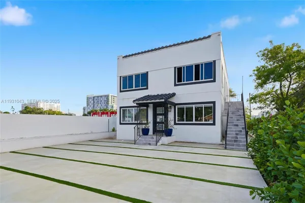 a view of a house with a balcony and large trees
