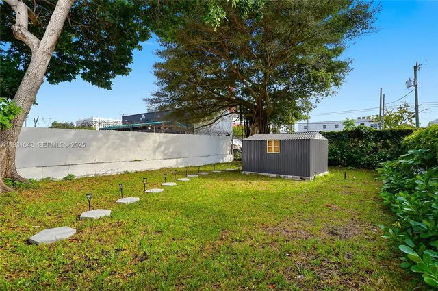 a view of a garden with a house in the background
