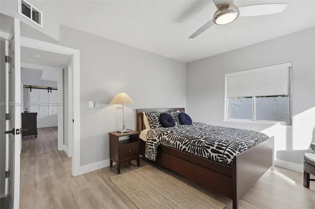 a bedroom with a bed and wooden floor