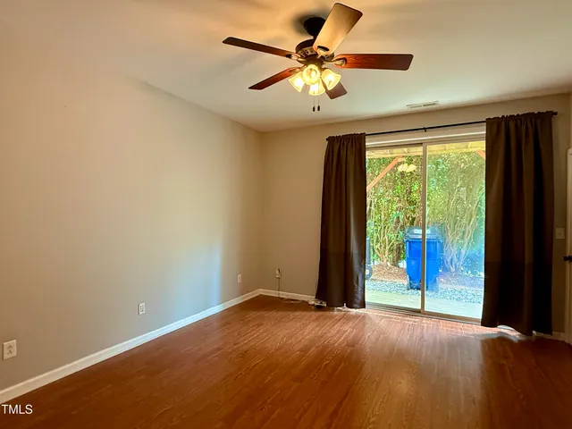 an empty room with a window and a ceiling fan