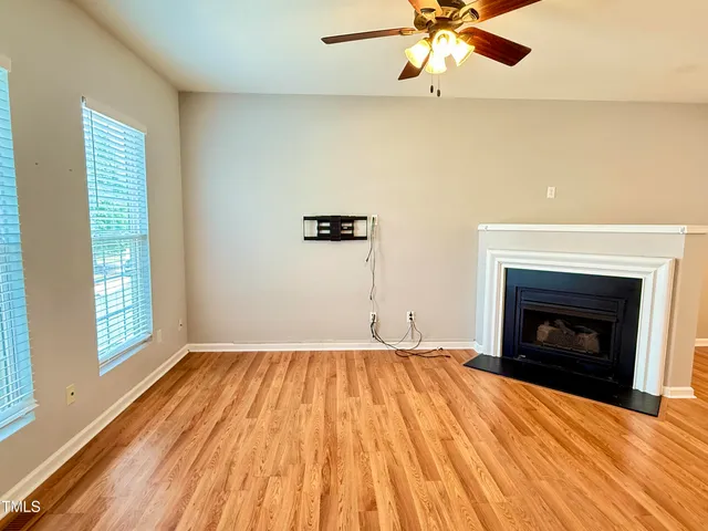 wooden floor fireplace and window in an empty room