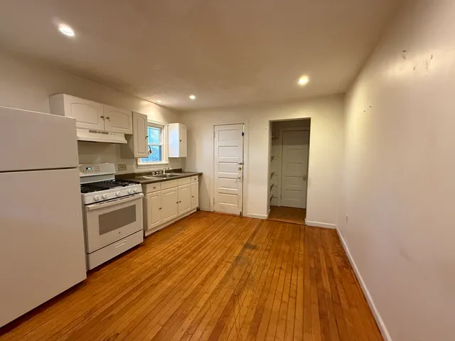 a kitchen with wooden floors and white appliances