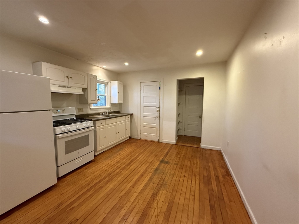5 Stoneland Road Worcester, MA 01603 - Photo 11 of 41 a kitchen with wooden floors and white appliances