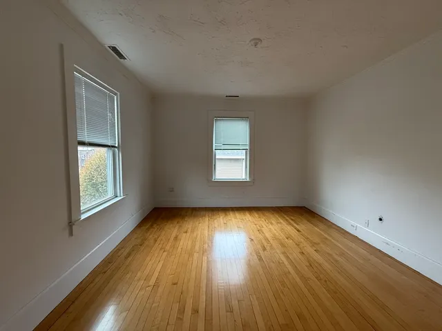 a view of a room with wooden floors and window