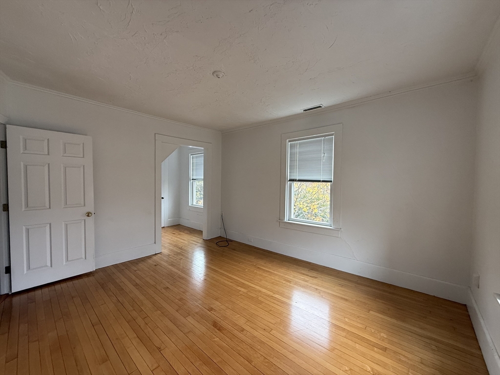 5 Stoneland Road Worcester, MA 01603 - Photo 24 of 41 a view of an empty room with wooden floor and window