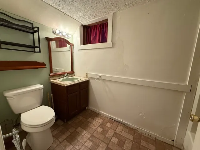 a bathroom with a toilet sink and mirror