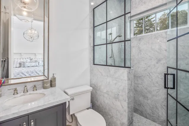 a bathroom with a granite countertop sink toilet and shower