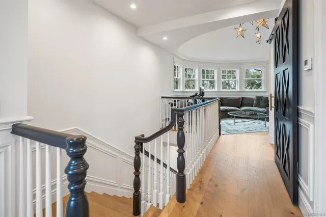 a view of a hallway with wooden floor and staircase