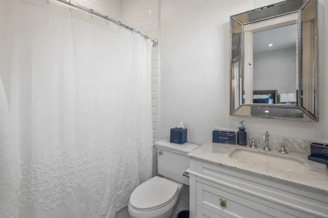 a bathroom with a toilet sink vanity and mirror