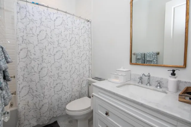 a bathroom with a granite countertop toilet sink and a mirror