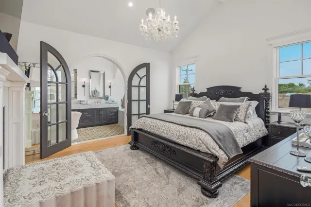 a spacious bedroom with bed and a chandelier