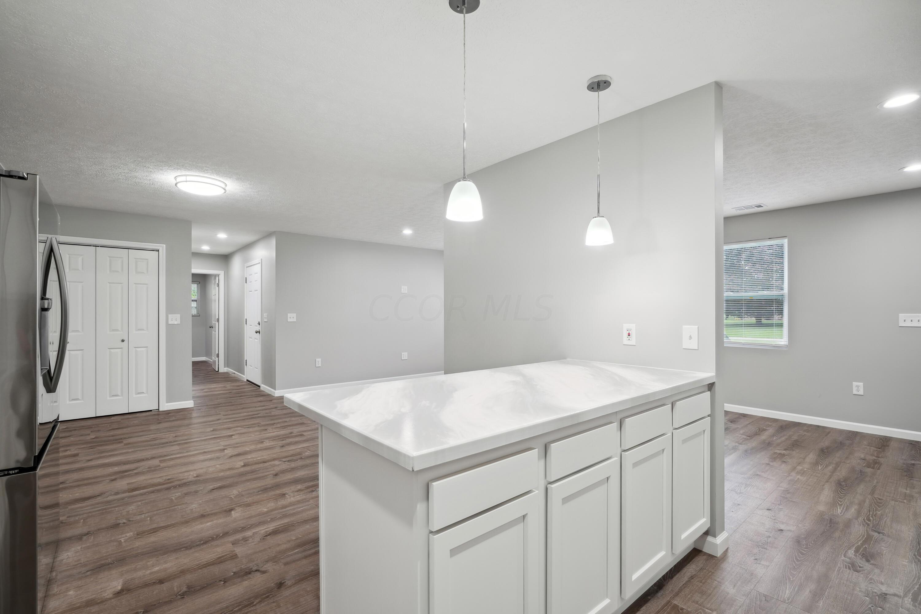 6705 Johnson Road Galloway, OH 43119 - Photo 11 of 30 Kitchen features white cabinetry, subway tile backsplash, stainless steel appliances, including a gas range, plus single basin sink, countertop seating with pendant lighting and pantry!