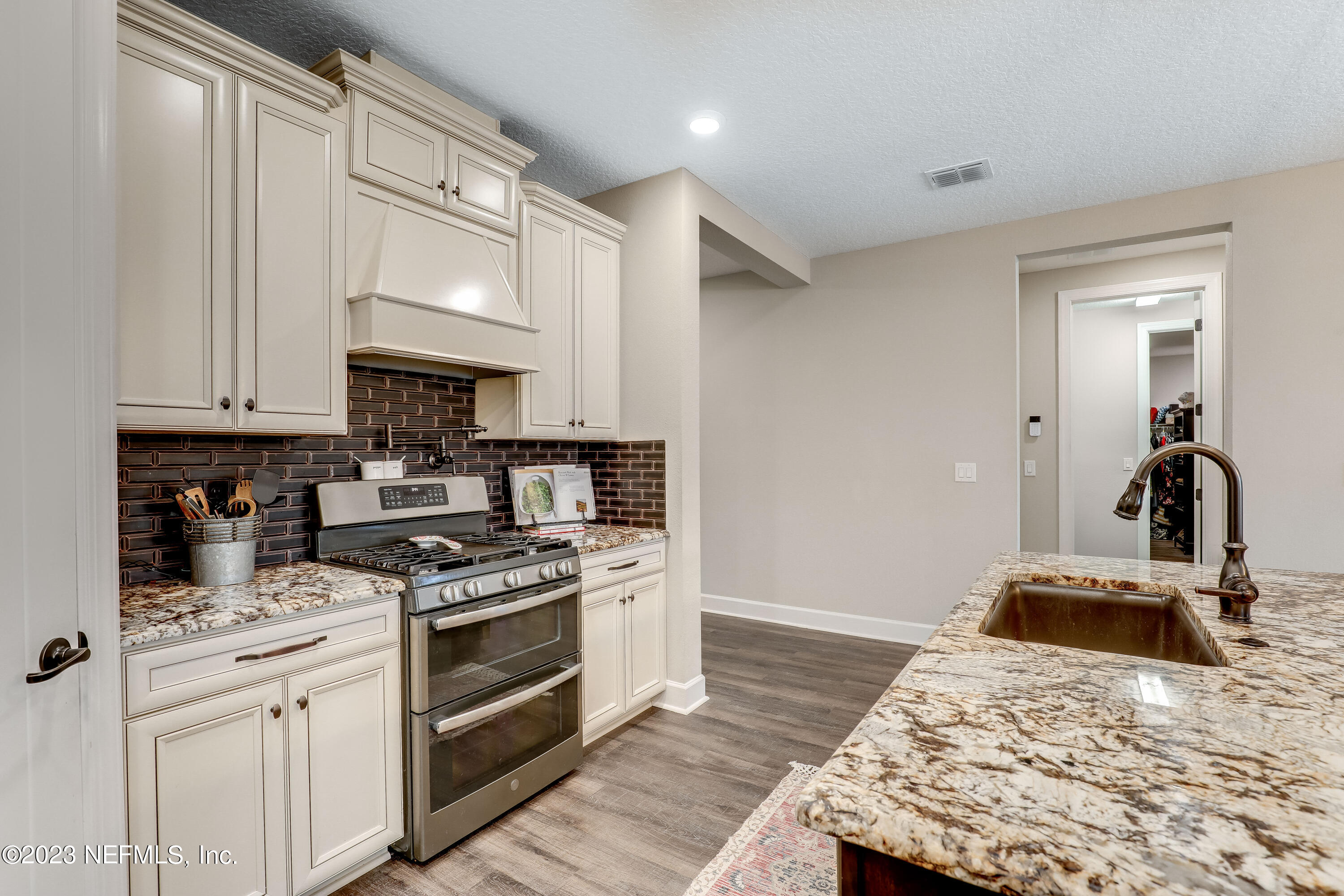85248 Champlain Drive Fernandina Beach, FL 32034 - Photo 13 of 79 a kitchen with granite countertop a sink stainless steel appliances and white cabinets