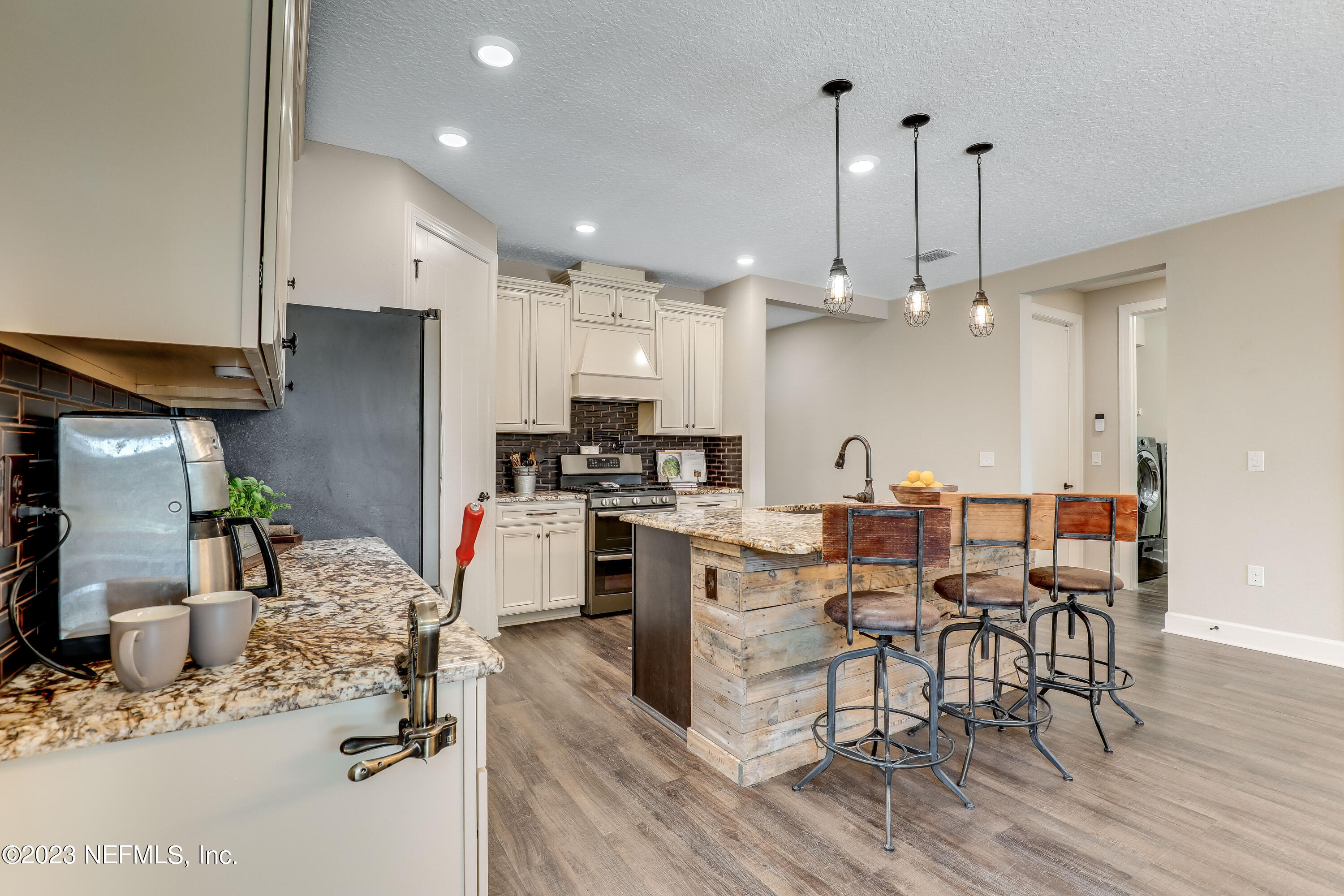 85248 Champlain Drive Fernandina Beach, FL 32034 - Photo 15 of 79 a kitchen with stainless steel appliances kitchen island granite countertop a refrigerator oven a stove a dining table and chairs with wooden floor