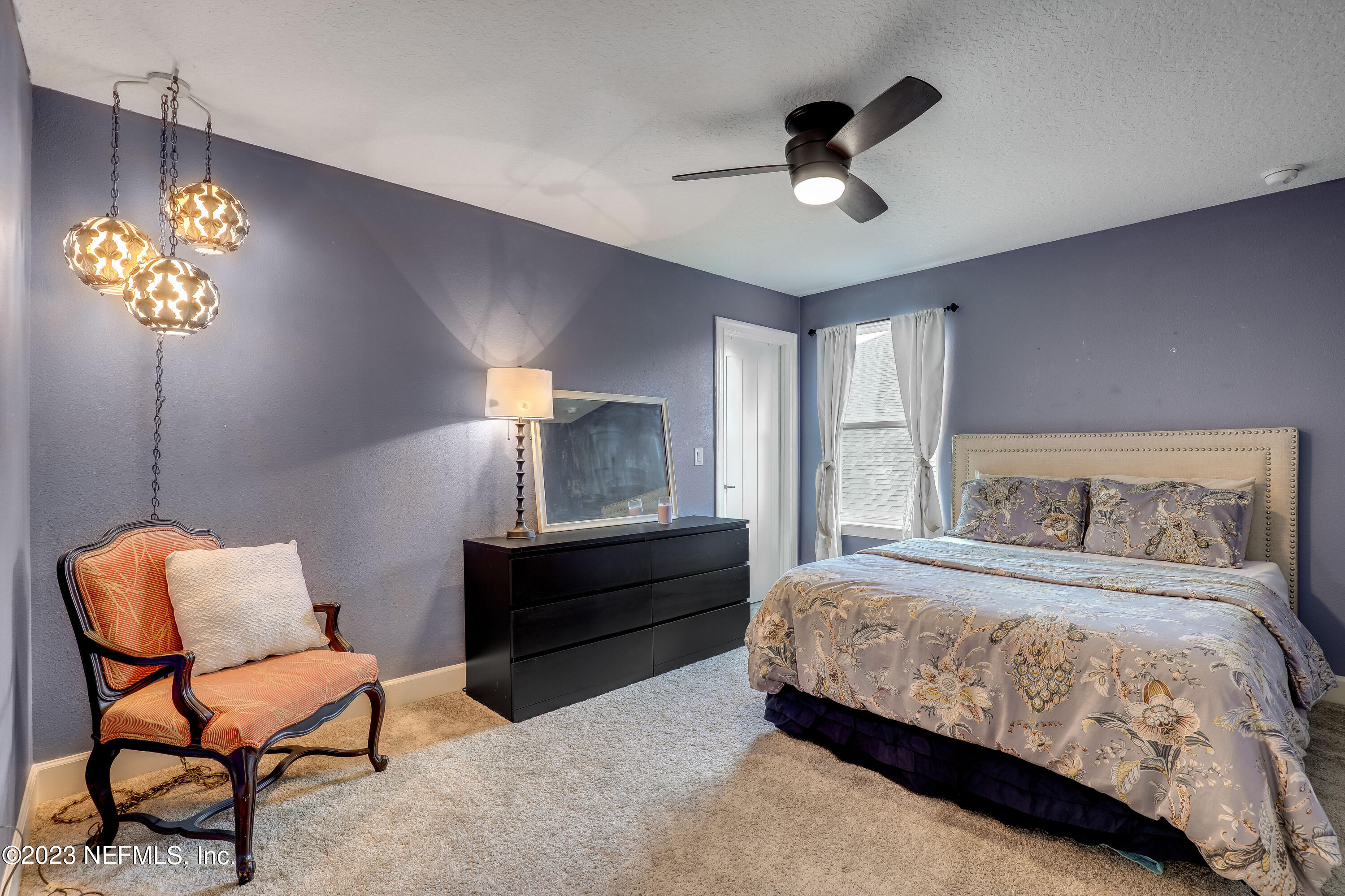 85248 Champlain Drive Fernandina Beach, FL 32034 - Photo 30 of 79 a bedroom with a bed and a chandelier