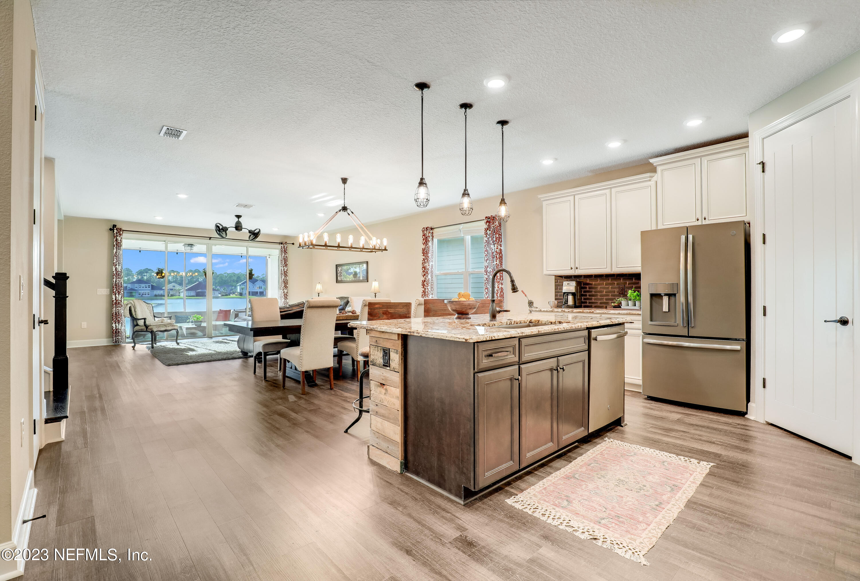 85248 Champlain Drive Fernandina Beach, FL 32034 - Photo 78 of 79 a kitchen with stainless steel appliances kitchen island granite countertop a refrigerator a stove a sink a dining table and chairs with wooden floor